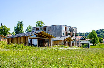 Blick auf die Chalets Woidhaisl und das Naturhotel mit Liegewiese und Blühwiese